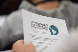 Person holding program of the Coloquio