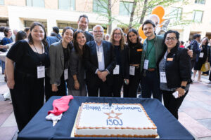 The Knight Center team standing around a cake for the 25th anniversary of ISOJ